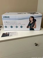 Box showing brand, product name and image of massager