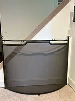 Front view of curved metal mesh fireplace screen showing overall design