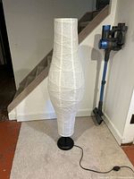 Full view of lamp front, showing rice paper shade, black base, cord with foot switch