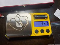 Bracelet and broken ring on digital scale reading 3.97 g