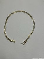 Full view of yellow gold link bracelet laid flat