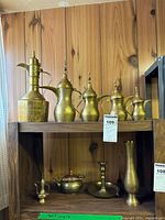 Group shot showing all nine brass pieces on two shelves