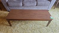 Top view of rectangular manufactured wood coffee table in front of sofa