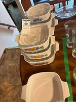 Stack of graduated CorningWare casseroles showing patterns and lids