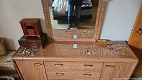 Overall view of dresser top with two wooden jewelry boxes and spread of jewelry pieces