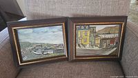 Both framed paintings on chair
