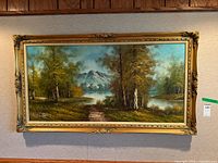 Full view of framed landscape painting on wall