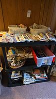 Full shelving unit with storage bins, baskets and stacked sewing pattern magazines