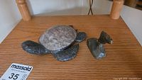 Turtle body and detached shell beside small carving