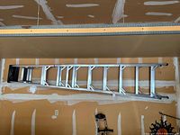 Full ladder hung horizontally on garage wall