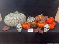 Full lot view with pumpkins, skulls, leaves on black backdrop