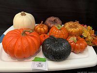 All pumpkins and leaf pick displayed on white surface
