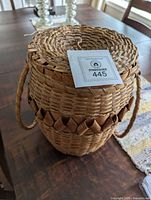 Front view of woven basket with lid and handles