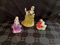 Three Royal Doulton figurines grouped
