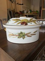 Front view of porcelain casserole showing chestnut and grain motifs and lid in place