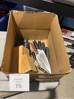 Box showing wooden knife block and assorted knives