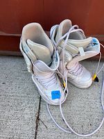 Full view of both white Burton snowboard boots with laces
