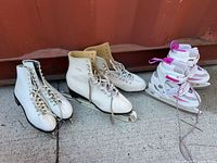 Both pairs of skates side by side on concrete