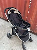 Front-angle view showing stroller, child tray, wheels, frame color