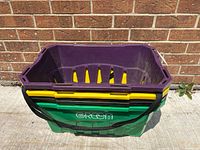 Nested stack of grocery bins showing colors, strap and front marking