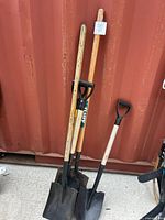 All four shovels standing, showing handles and grips