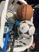 Basket with Wilson basketball, soccer ball, rackets, bat, paddles, rope, dumbbell