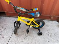 Full view of yellow Nakamura kids bike with training wheels