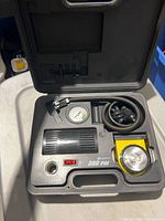 Compressor, gauge, hose and flashlight inside carry case