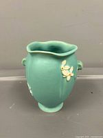 Front of turquoise Weller vase with white floral relief