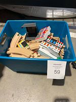 Bin containing assorted wooden track pieces and printed blocks
