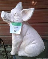 Left side view of pink concrete pig figurine