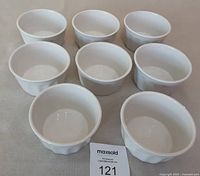 Top view of eight matching white ceramic ramekins