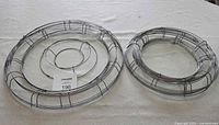 Nest of larger diameter wire wreath frames with MaxSold tag showing lot number