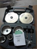 Open carrying case showing all components: 2 diamond blades, 3 hole saws, 2 arbors, hardware packet