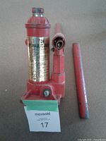 Front view of red 1-ton hydraulic bottle jack with two detachable handle bars