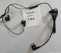 Full view of Samsung wired earbuds, inline remote, micro-USB connector, cable clip