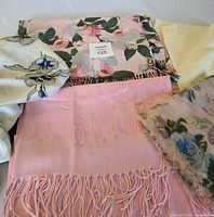 All five shawls and scarves grouped on table