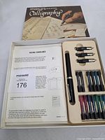 Entire calligraphy set in box showing pen, extra nibs, ink cartridges, booklet and guideline sheet
