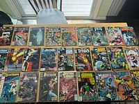 Tabletop view showing 24+ comics laid out in four rows