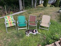 Four vintage aluminum lawn chairs with varied vinyl seating patterns displayed on lawn