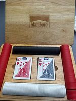 Open wooden case showing Marlboro logo, chips, and cards