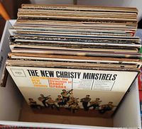 Open box showing stacked LPs, top record The New Christy Minstrels