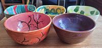Five painted ceramic bowls displayed, front and top views