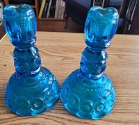 Two blue pressed glass candlestick holders on table