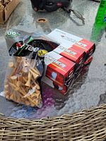 Bag of wooden tees beside stacked Burner sleeves