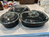 All three black ceramic casseroles with lids shown together