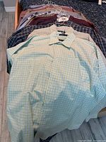 All 14 plaid shirts on hangers displayed on bed