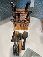 Knife block with knives inserted; additional utensils laid in front