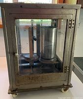 Front view of balance scale in metal and glass cabinet