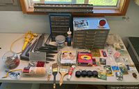 Entire lot on table showing cabinets, brackets, painting supplies, hardware packages